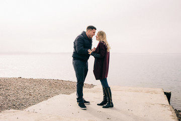 the guy makes an offer to the girl by the water