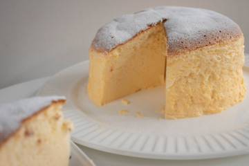 Japanese jiggly cheesecake topped with sugar Powder with slice on plate.