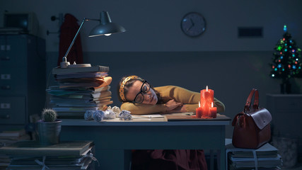Exhausted businesswoman sleeping on the desk at night