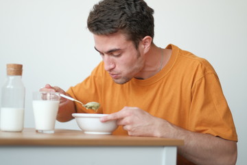 The guy in a yellow T-shirt is having breakfast