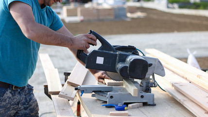  worker cutting wood with circular saw (softwood)