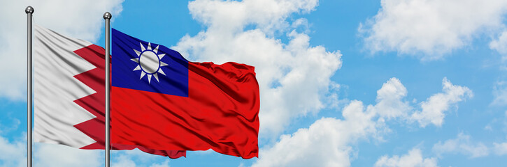 Bahrain and Taiwan flag waving in the wind against white cloudy blue sky together. Diplomacy concept, international relations.
