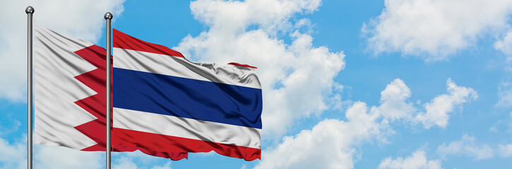 Bahrain and Thailand flag waving in the wind against white cloudy blue sky together. Diplomacy concept, international relations.