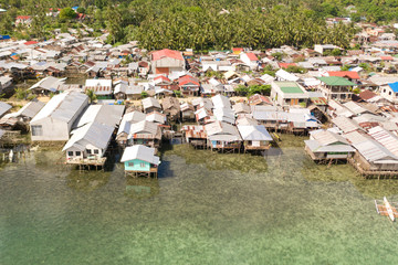 Fototapeta na wymiar Dapa city, Siargao, Philippines. Houses on stilts, fishing village top view. Houses of local residents on the beach.
