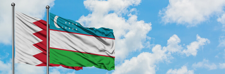 Bahrain and Uzbekistan flag waving in the wind against white cloudy blue sky together. Diplomacy concept, international relations.
