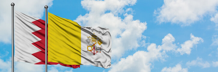 Bahrain and Vatican City flag waving in the wind against white cloudy blue sky together. Diplomacy concept, international relations.