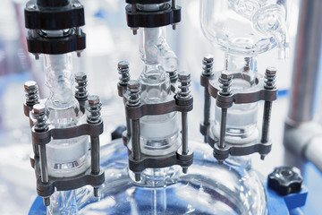 The upper part of the chemical reactor. The glass reactor lid is equipped with piping.