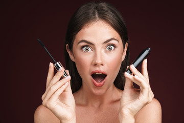 Image of excited half-naked woman looking at camera and holding mascara