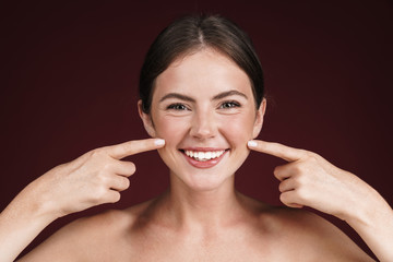 Image of half-naked woman smiling and pointing fingers at her cheeks