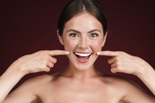 Image of half-naked woman laughing and pointing fingers at her cheeks