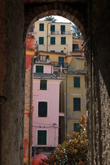 Typical houses of the village of Vernazza in the Cinque Terre framed by an arch of a narrow word.