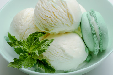 Balls of fresh ice cream with a sprig of mint and mint macaroon.