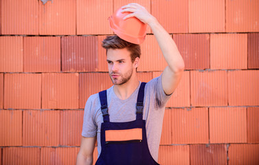 safe your head. worker brick wall background. professional repairman hard hat. man build house....