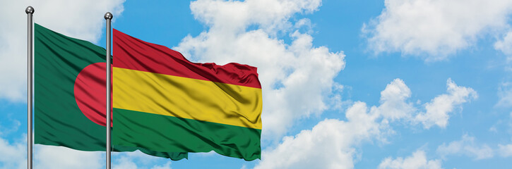Obraz premium Bangladesh and Bolivia flag waving in the wind against white cloudy blue sky together. Diplomacy concept, international relations.