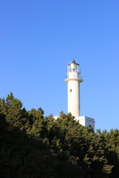 Beacon of Lefkada island south cape lighthouse tower shine at sunlight in summer, clear blue sky at background