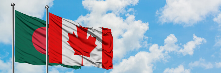 Naklejka premium Bangladesh and Canada flag waving in the wind against white cloudy blue sky together. Diplomacy concept, international relations.