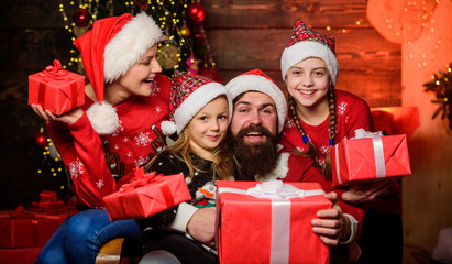 Fototapeta na wymiar Sharing memories. Happy family celebrate new year and Christmas. open xmas present. gifts from santa. santa father at decorated tree. small girls sisters with parents. cheerful mother love children