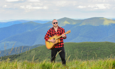 Music for soul. Playing music. Sound of freedom. In unison with nature. Acoustic music. Musician hiker find inspiration in mountains. Keep calm and play guitar. Man with guitar on top of mountain