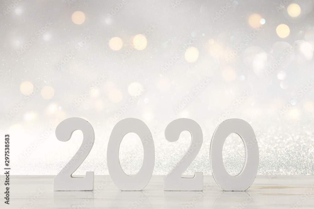 Wall mural background of 2020 happy new year concept, wooden numbers over table and glitter background