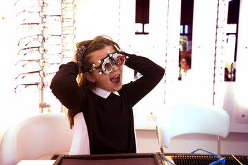 ophthalmologist examining cute little girl with modern equipment - Image