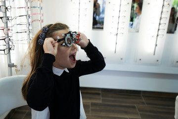 ophthalmologist examining cute little girl with modern equipment - Image