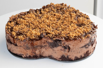 Chocolate nut mousse Cake decorated with crushed nuts. Heart shape.