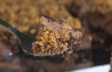 Chocolate Mousse Cake Slice on Tea Spoon Decorated Crushed Nuts.