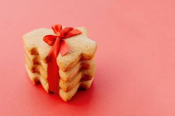 Stack of shortbread cookies in the shape of Christmas tree tied with beautiful red ribbon.