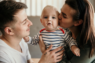Family connections. Happy young family of three smiling while spending free time at home