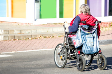 Woman in a wheelchair. Social protection. Support for the disabled. Social problems. Old man in a wheelchair. Disabled person on the way home.