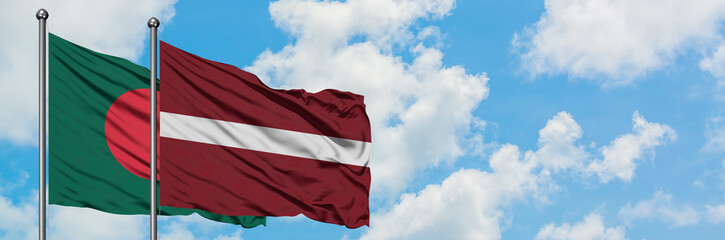Fototapeta na wymiar Bangladesh and Latvia flag waving in the wind against white cloudy blue sky together. Diplomacy concept, international relations.