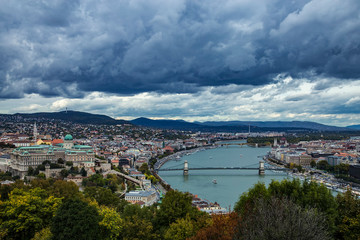Fototapeta na wymiar Autumn panoramic view from Gellert Hill to Buda Castle and King Palace Budavári Palota of the Hungarian kings and river Danube with Széchenyi Chain Bridge on stormy weather