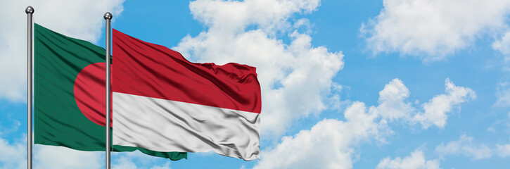 Bangladesh and Monaco flag waving in the wind against white cloudy blue sky together. Diplomacy concept, international relations.