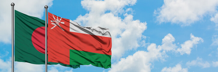 Bangladesh and Oman flag waving in the wind against white cloudy blue sky together. Diplomacy concept, international relations.