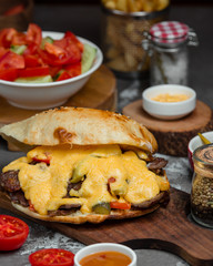 burger with cotlet and cheese served with fresh vegetable