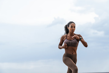 Fototapeta na wymiar Image of healthy african american woman in sportswear running outdoors