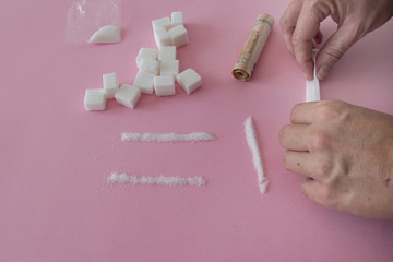 Sugar is a drug. Hand of a woman with sugar imitating cocaine