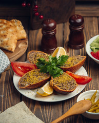 fried minced meat in the bread with piece of tomato and lomen