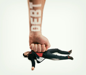 The big human fist with text - debt bring down the man off his feet. Concept of  large debts. Image.