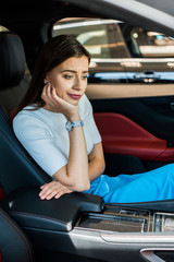 upset woman sitting in new modern car