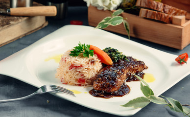 fried salmon is served with boiled rice and ketchup