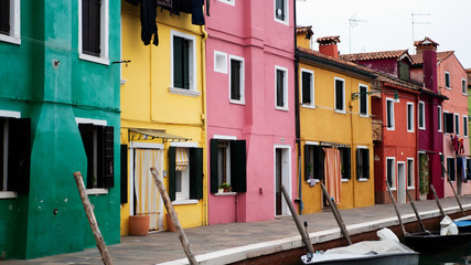 Fototapeta na wymiar Colorful island called Burano, next to Venice, Italy. Lovely painted houses and canals.
