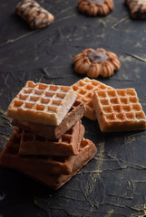 stack of waffles on a black table, cookies background,