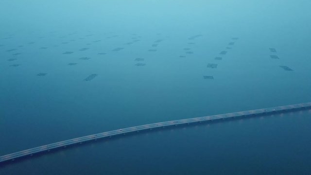 Aerial Sultan Abdul Halim Muadzam Shah Bridge with fish farm as background in dusk.