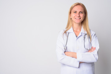 Portrait of happy young blonde woman doctor smiling with arms crossed