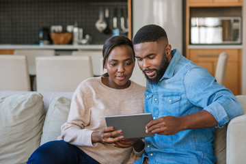 Young African American couple using a tablet together at home