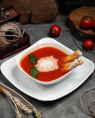 tomato soup with dried crust and mint in the bowl