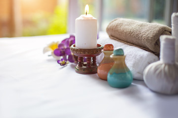 Spa treatments on White spa massage bed with candles, massage oil