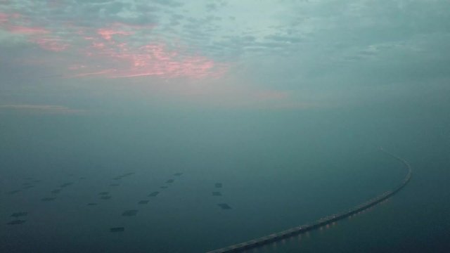Aerial Sultan Abdul Halim Muadzam Shah Bridge with fish farm and colorful cloud.