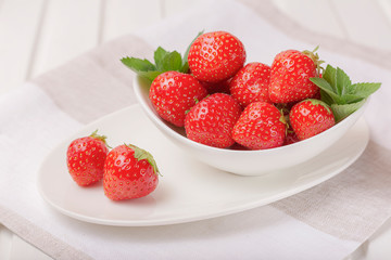 Strawberries on a white plate on a light background